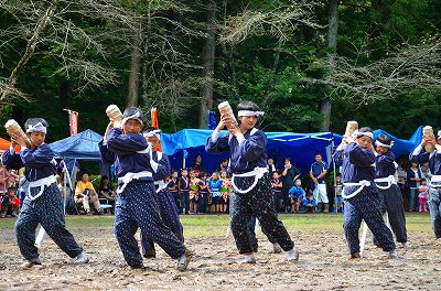 小さな俵を持って踊る子供たちの写真