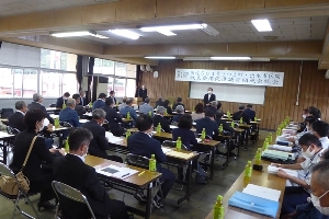 会議場で座って話を聞いている議員の写真
