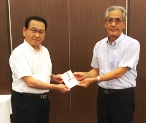 中種子町議会議長から義援金を受領しているさつま町議会議長の写真