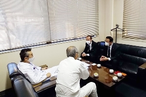 誘致企業の本社応接室にて、机を囲んで話を聞いている写真