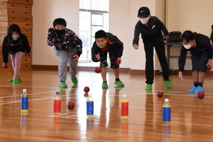 体育館でボッチャのボールを投げている子どもたちの写真
