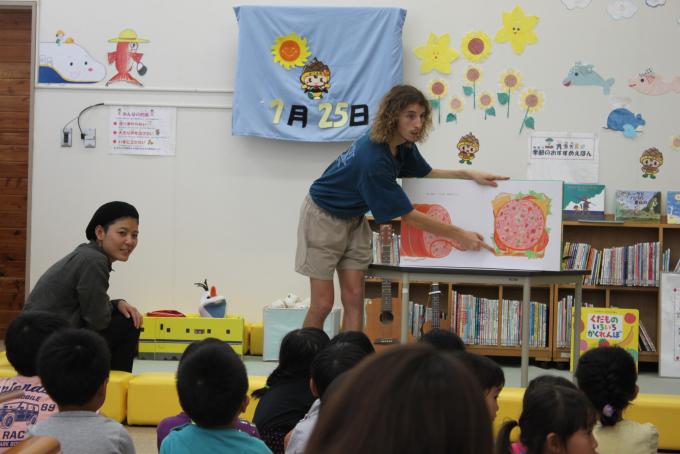 女性が子どもたちに読み聞かせしている写真