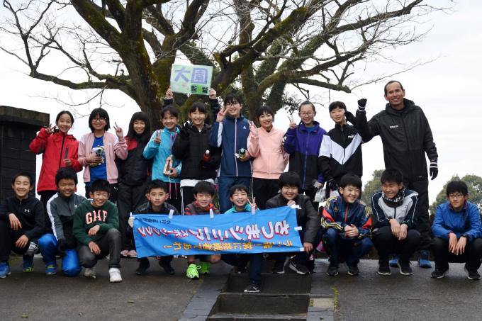 垂れ幕を持った小学生たちの集合写真