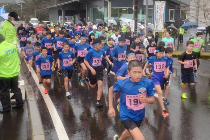 雨の中をスタートする子供たちと参加者の写真