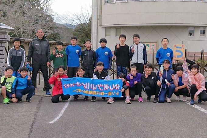 垂れ幕を持った小学生たちの集合写真