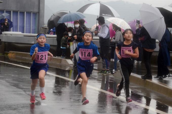 並んで全力で走る小学生たちの写真