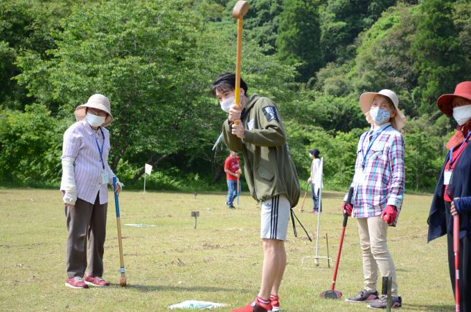 グラウンドゴルフのクラブを持ってボールの行方を見守る男性の写真