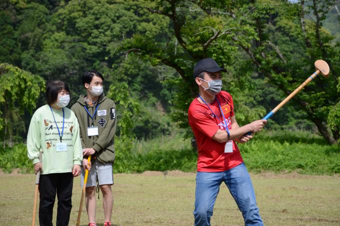 ボールを打った男性と、見守る女性の写真