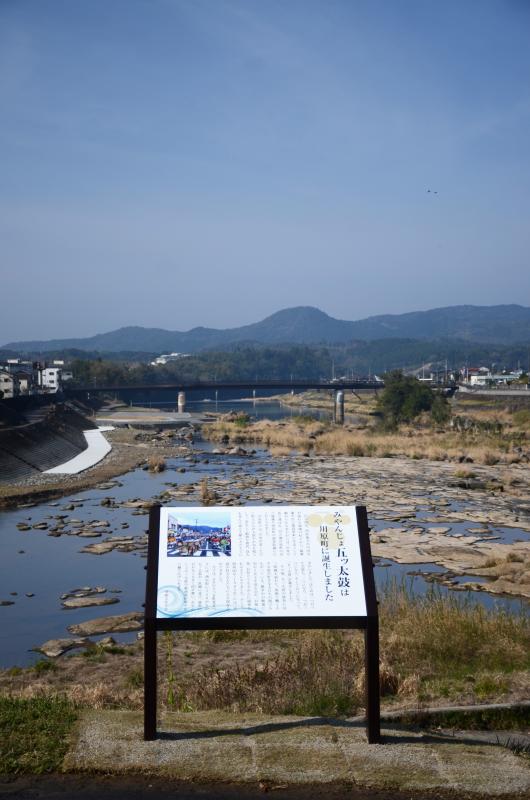 堤防沿いに設置されたみやんじょ五ッ太鼓のプレート写真