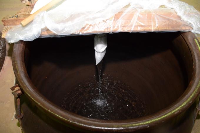 蒸留された焼酎の原酒が甕へ流れ落ちている写真