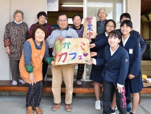 「なかっこカフェ」看板を寄付した6年生達と「なかっこカフェ」看板を持つなかっこカフェの人達の写真