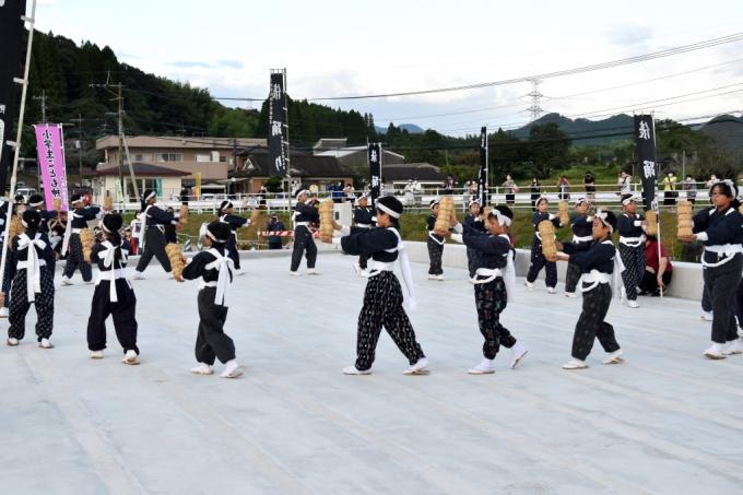 俵を持って輪になって踊っている写真