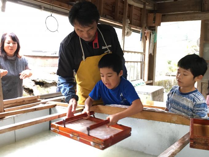 子どもが紙漉き体験している様子の写真