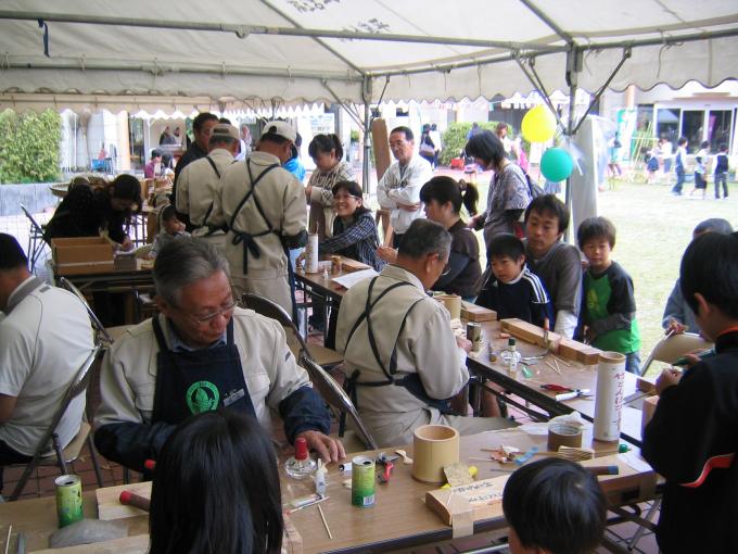 竹細工教室で指導員による実演している様子を子ども達が見ている写真