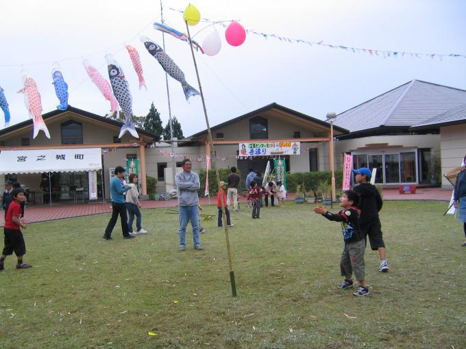 子ども達が竹とんぼで風船割りゲームをしている様子の写真