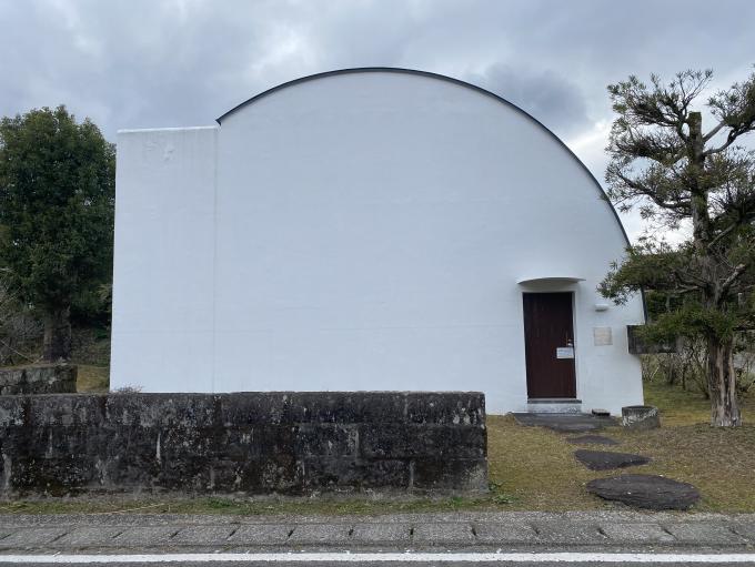 ドーム型の屋根で白い壁の記念館を正面から撮影した写真