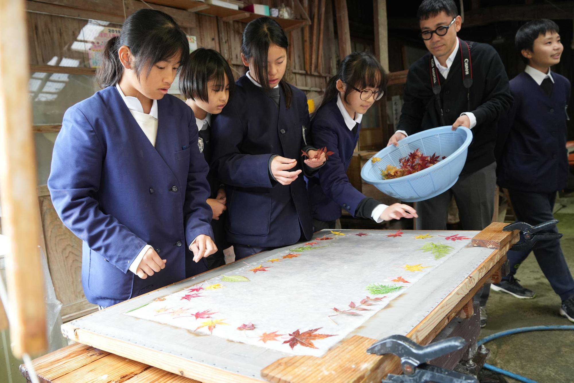 紅葉を飾る生徒20241213