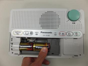 防災行政無線戸別受信機の電池フタを開け、乾電池をセットしている画像